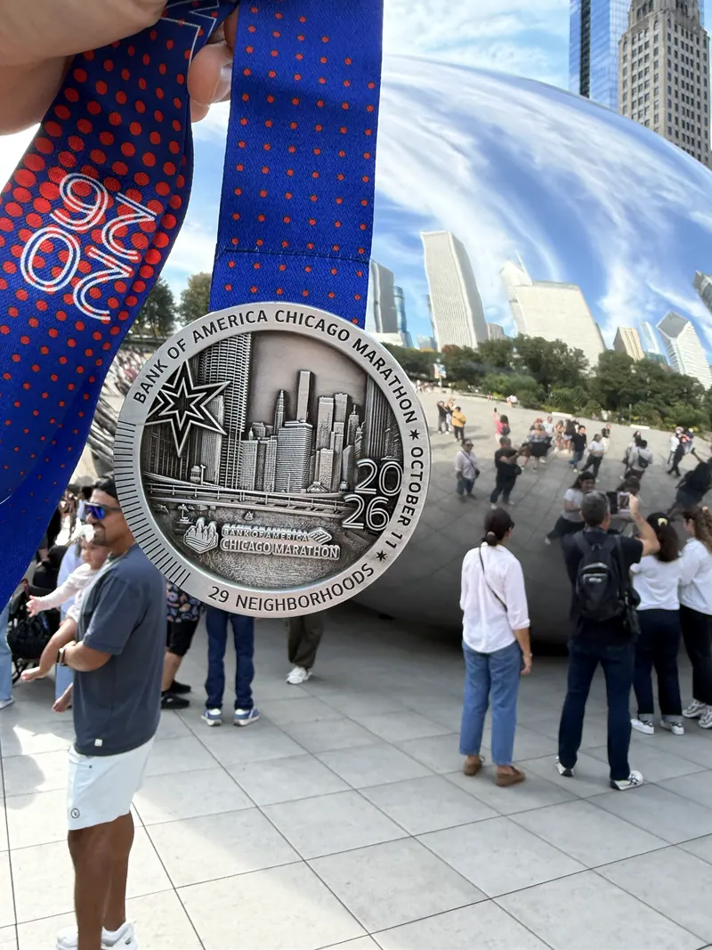 The finisher medal in front of Cloud Gate.