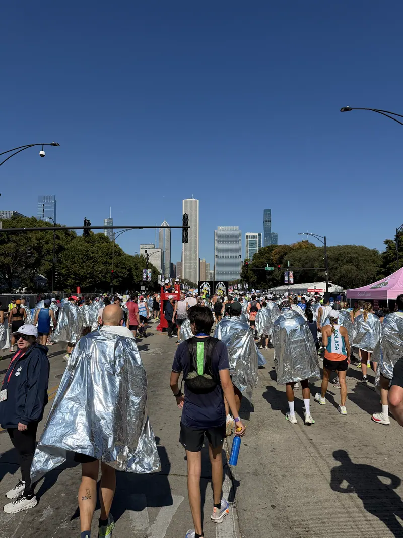 Finishers walking through the post-race area in foil blankets.